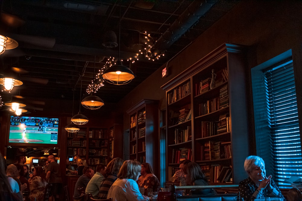 people seated near bookshelves