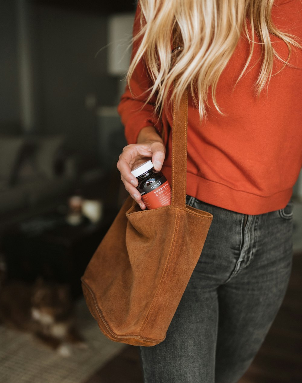 femme tenant une bouteille sur un sac