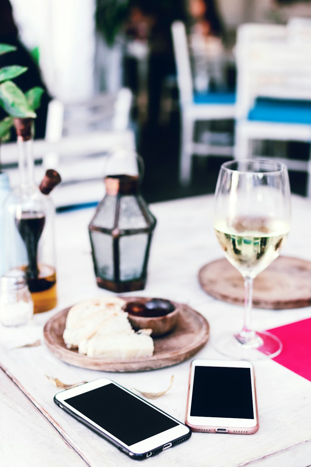 two smartphones beside wine glass