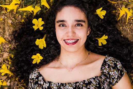 woman lying on ground with yellow flowers
