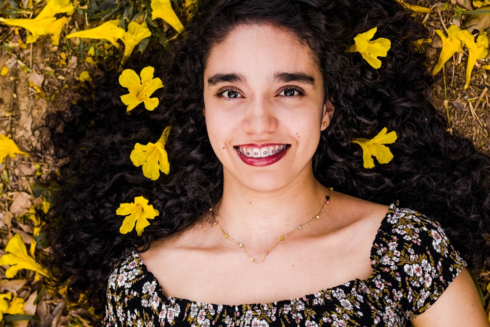 woman lying on ground with yellow flowers