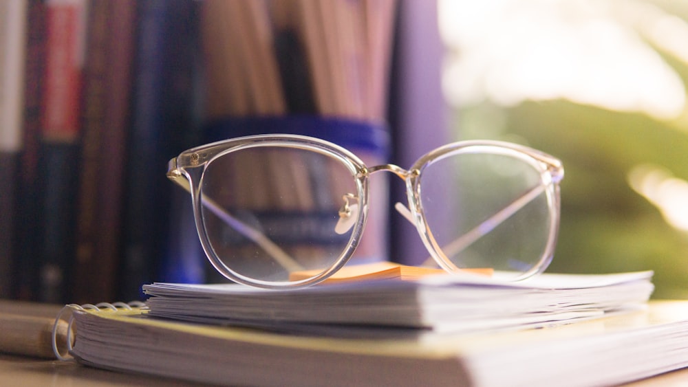 clear eyeglasses on pile of notebooks