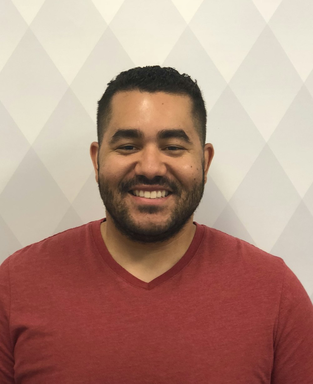 man smiling wearing maroon V-neck shirt