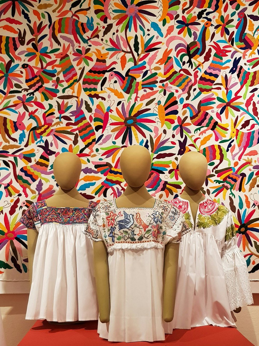 three mannequins on red surface