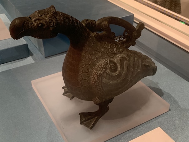 Intricate metal sculpture shaped like native mountain wildlife against a rustic backdrop.