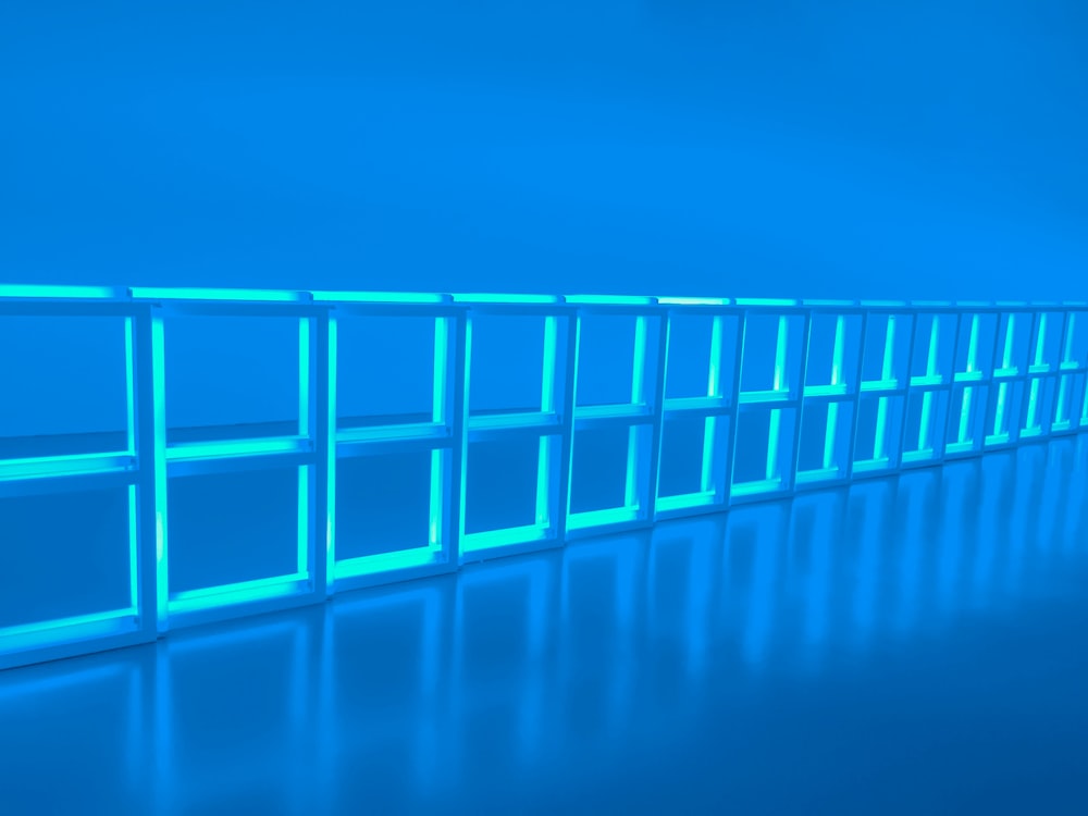 une rangée d’étagères bleues posées sur un sol bleu