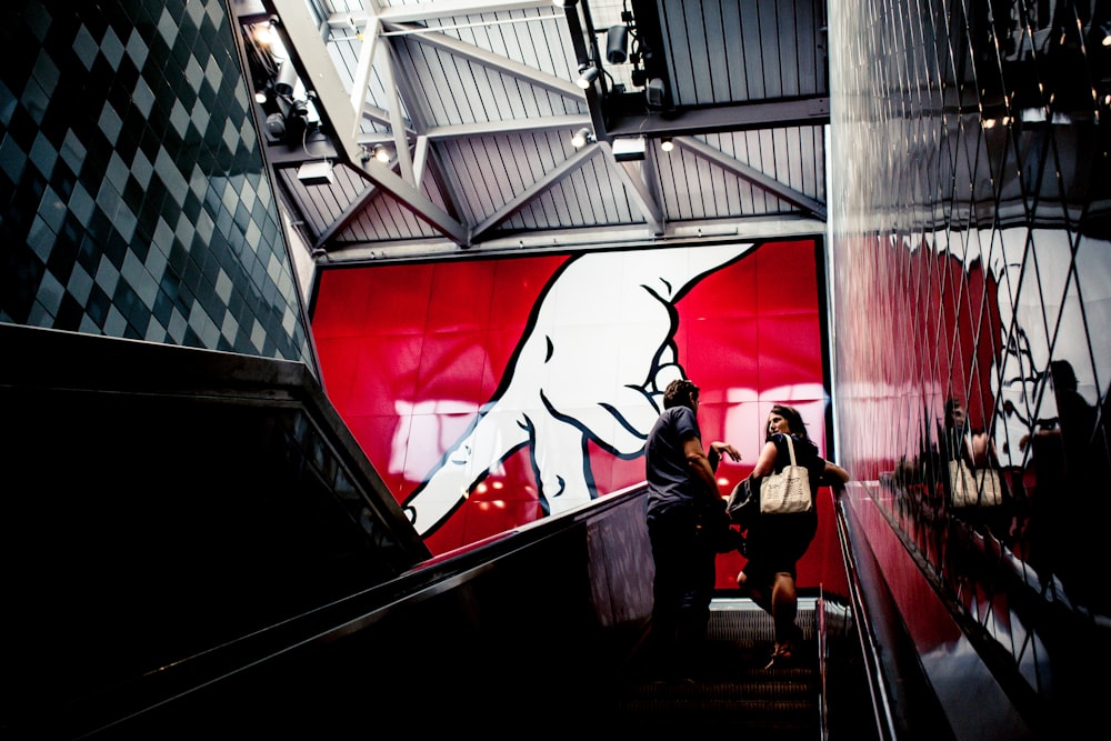 man and woman standing on escalator