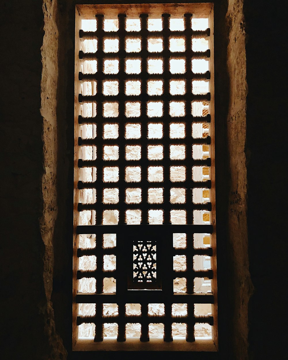 une fenêtre dans un mur de pierre avec la lumière qui la traverse