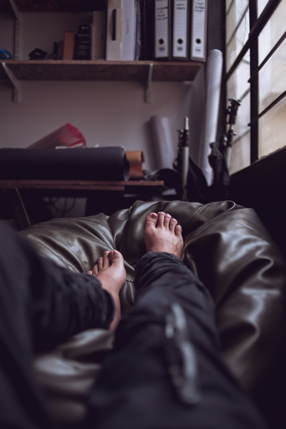 person lying on sofa wearing black jeans