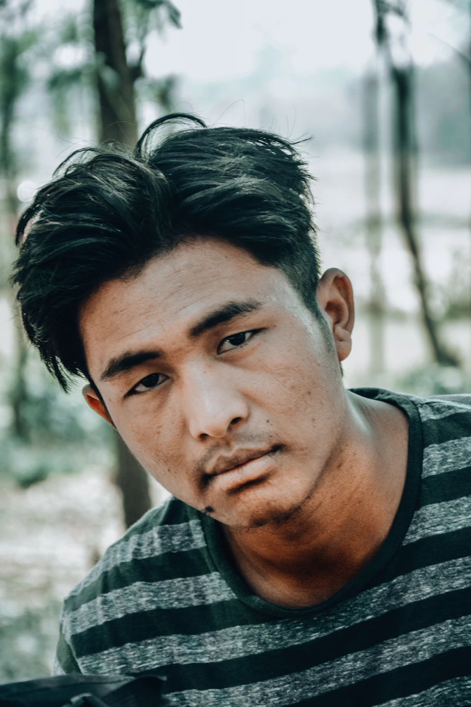 Young man with dark hair looks directly at the camera in intense gaze