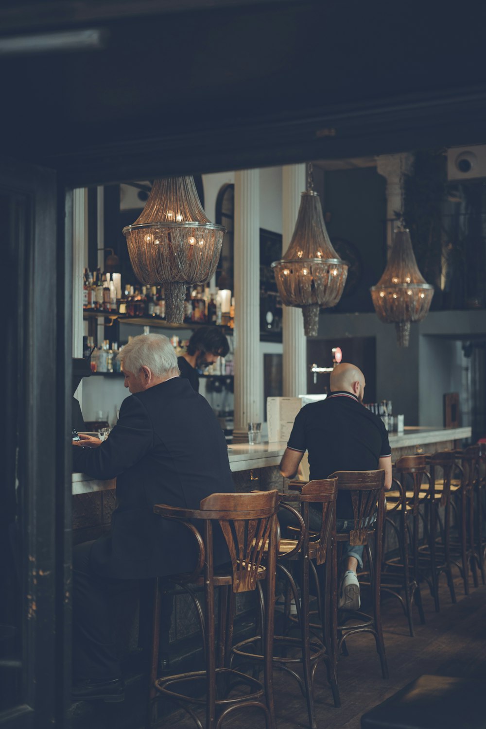two men sitting on bar chairs