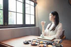 Lifestyle shot of a person enjoying millet snacks with a cup of herbal tea in a cozy kitchen setting.
