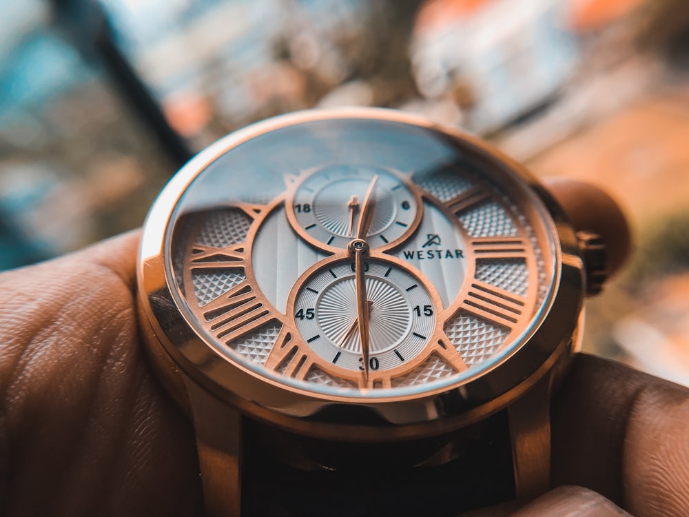 round gold-colored chronograph watch