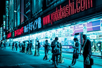 people standing near lighted building at night