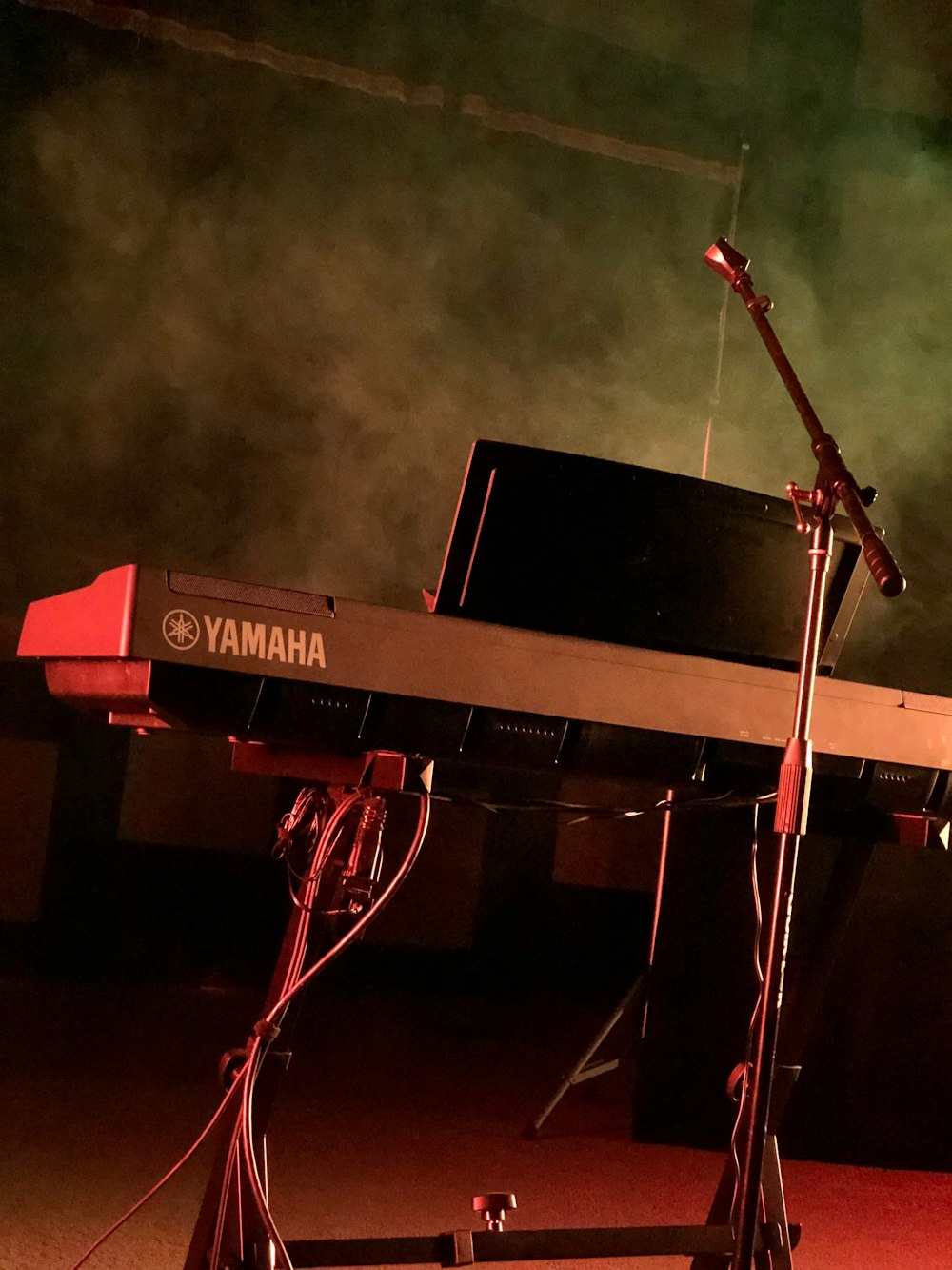 black and gray Yamaha electronic keyboard near microphone stand