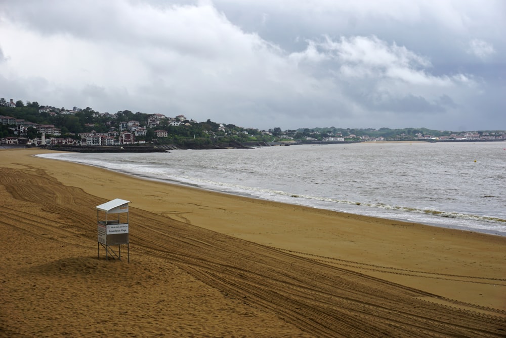 grey lifeguard tower on shore during daytime