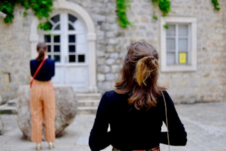 selective focus photography of woman standing in front on buidling