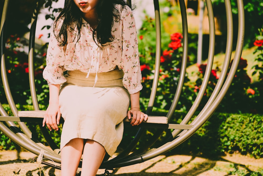 woman sitting on outdoor chair near flower garden