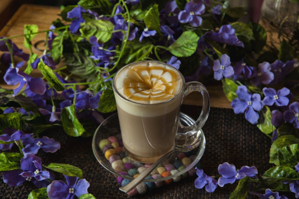 latte in glass cup surround with purple flowers