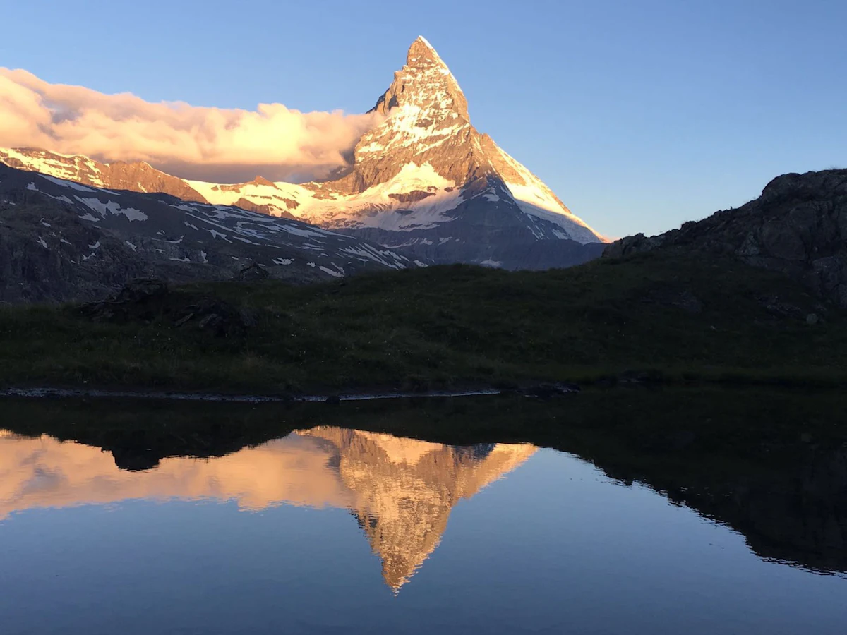 The Matterhorn reflected in a still Alpine lake at dawn