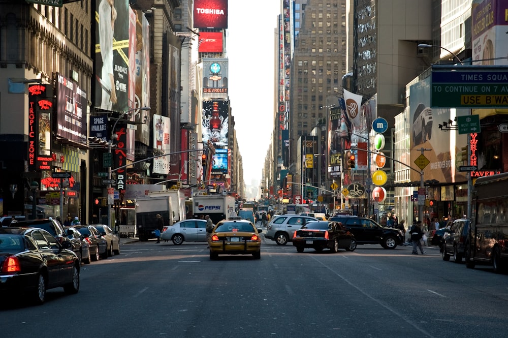 cars passing by buildings during daytime