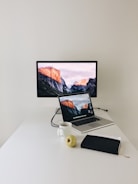 A clean, minimalist workspace with a laptop displaying a grid-based data visualization in deep slate blue and matte black.