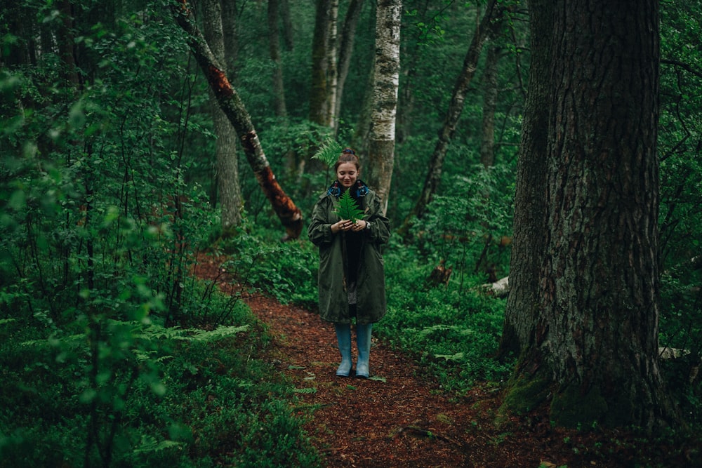 woman in black jacket holding leaf