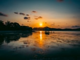 A serene view of a floating house on tranquil waters at sunset.
