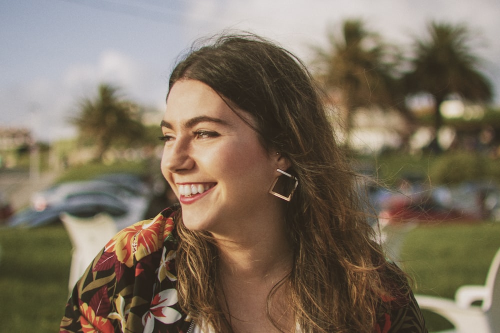 smiling woman wearing black and orange floral top