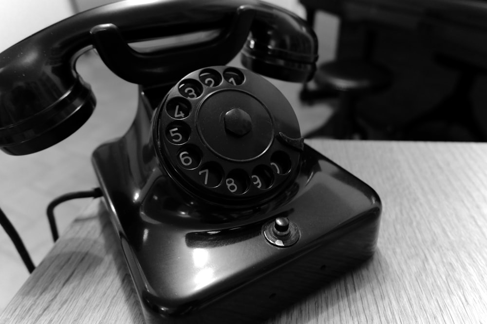 shallow focus photo of black rotary telephone