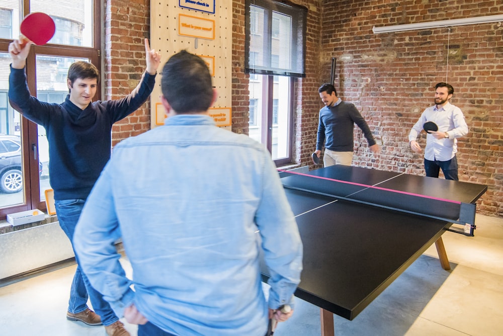 Quattro uomini che giocano a ping pong