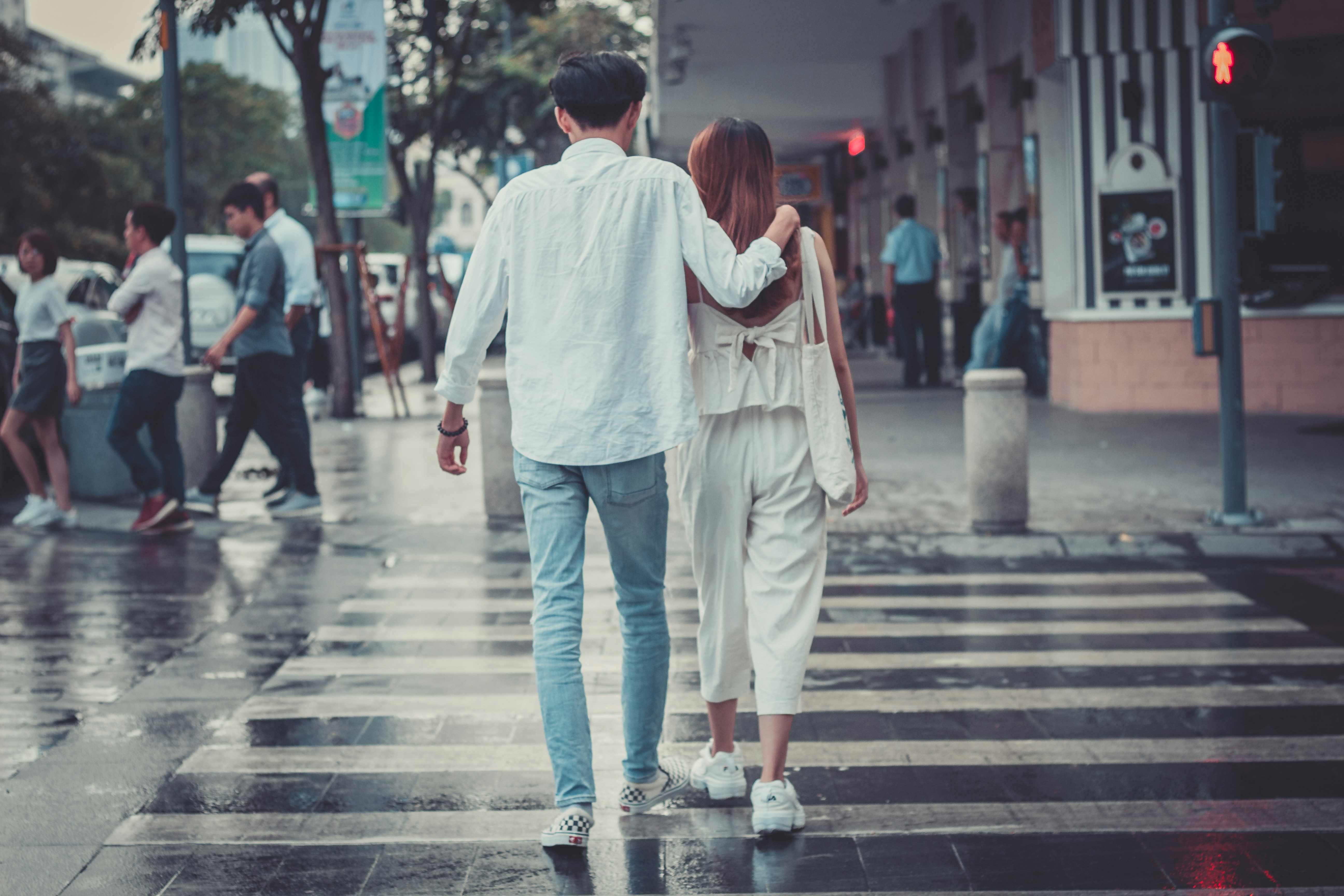 man and woman crossing pedestrian lane asphalt teams background