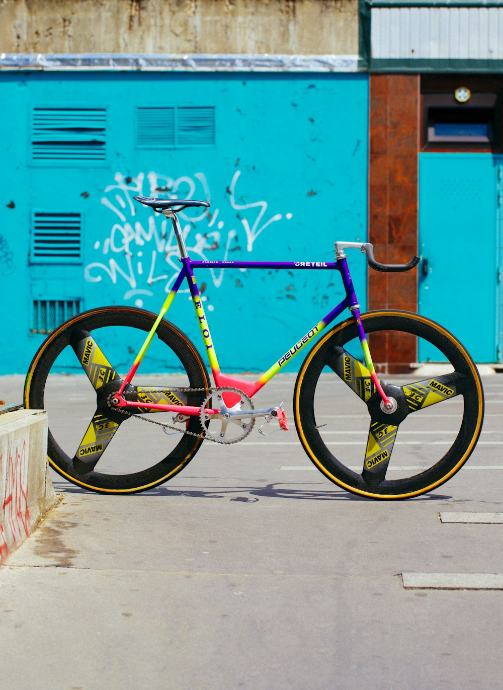 Bicicleta de carretera amarilla, rosa y azul