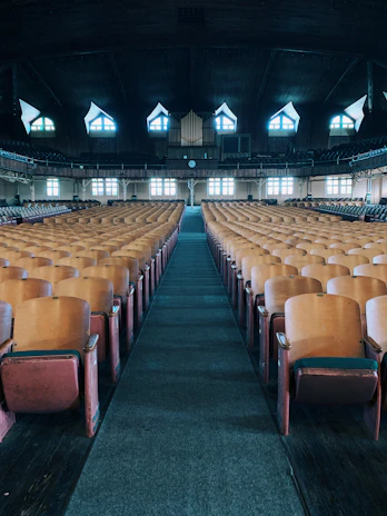 A historic concert hall interior with rows of wooden seats and a grand stage, inviting listeners into the past.