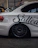 A happy customer wearing a saltoria branded hoodie, standing beside a sleek car.