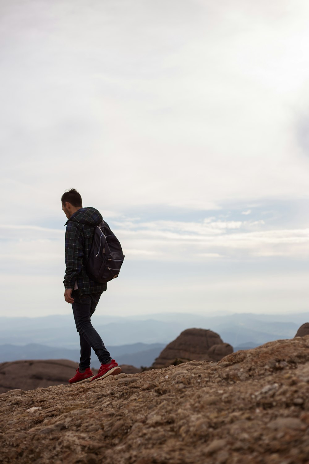 trekking man in black denim jeans carrying black backpack