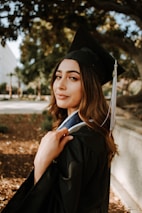 woman in black graduation gown with black mortar board