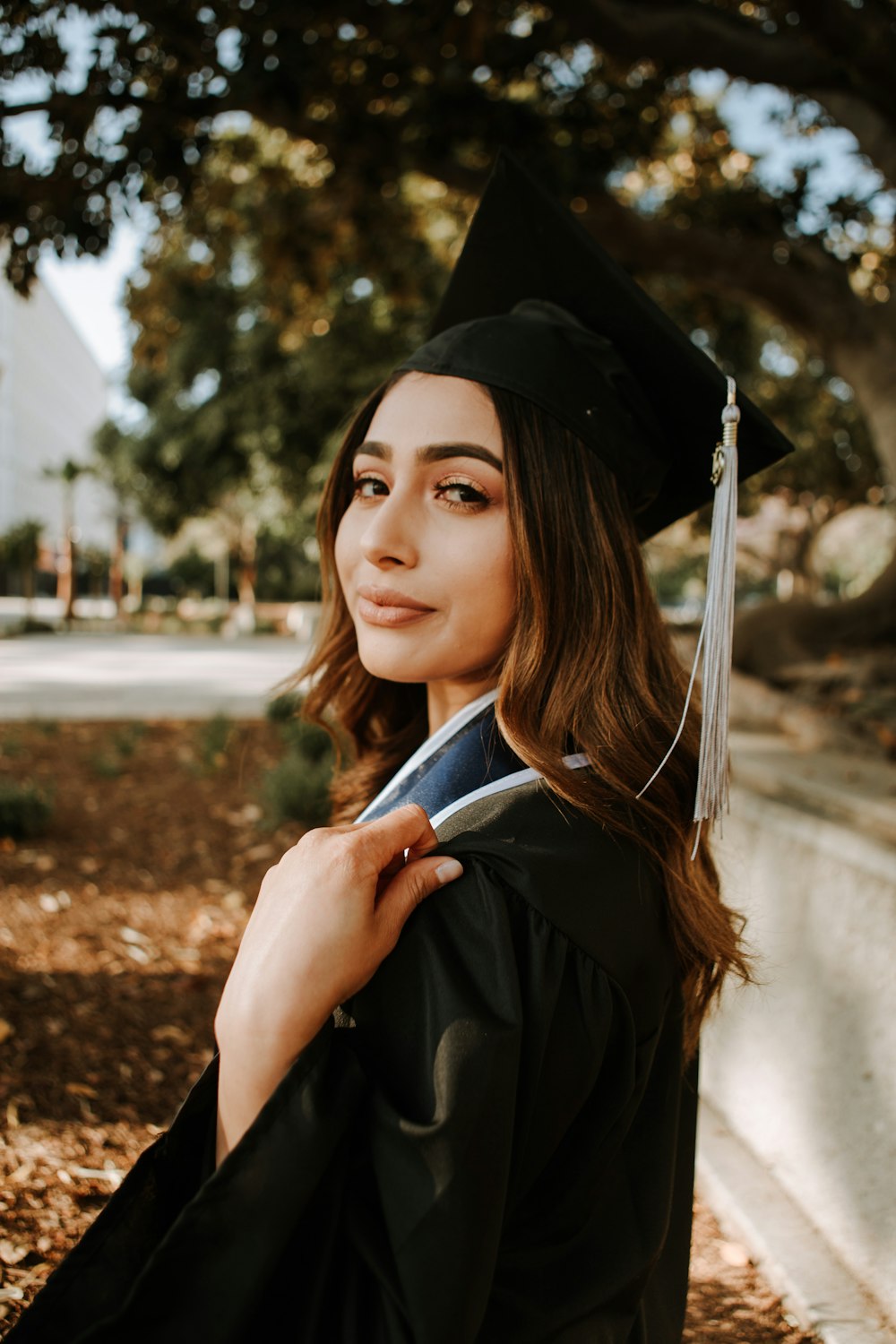 Mujer en vestido de graduación negro con tablero de mortero negro