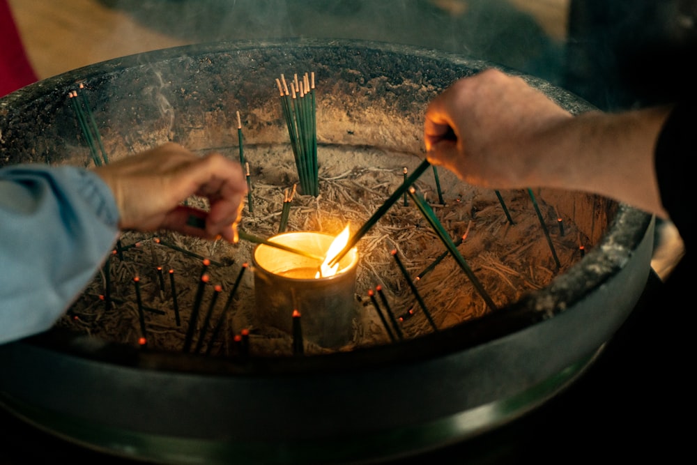 man in black shirt lighting green incense candle