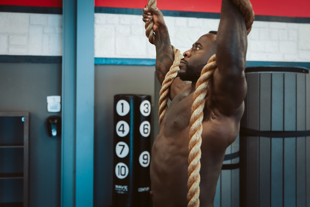 man holding brown rope exercising