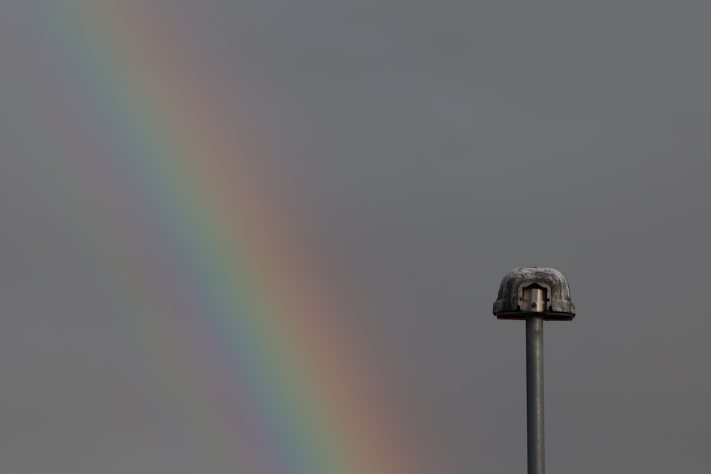 Ein Regenbogen ist am Himmel über einer Stange zu sehen