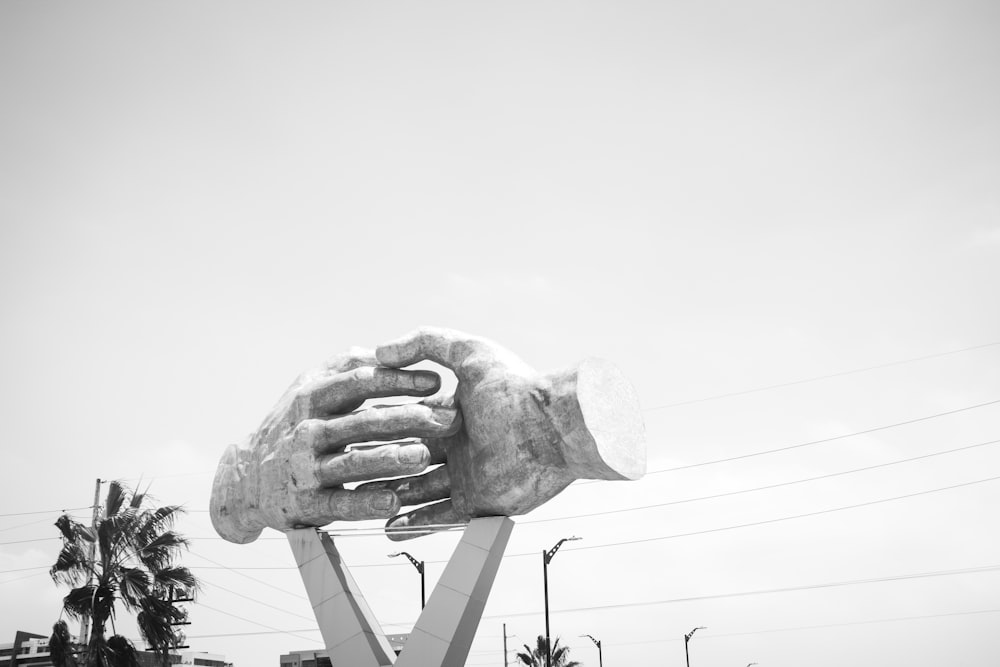 grayscale photo of shaking hands statue