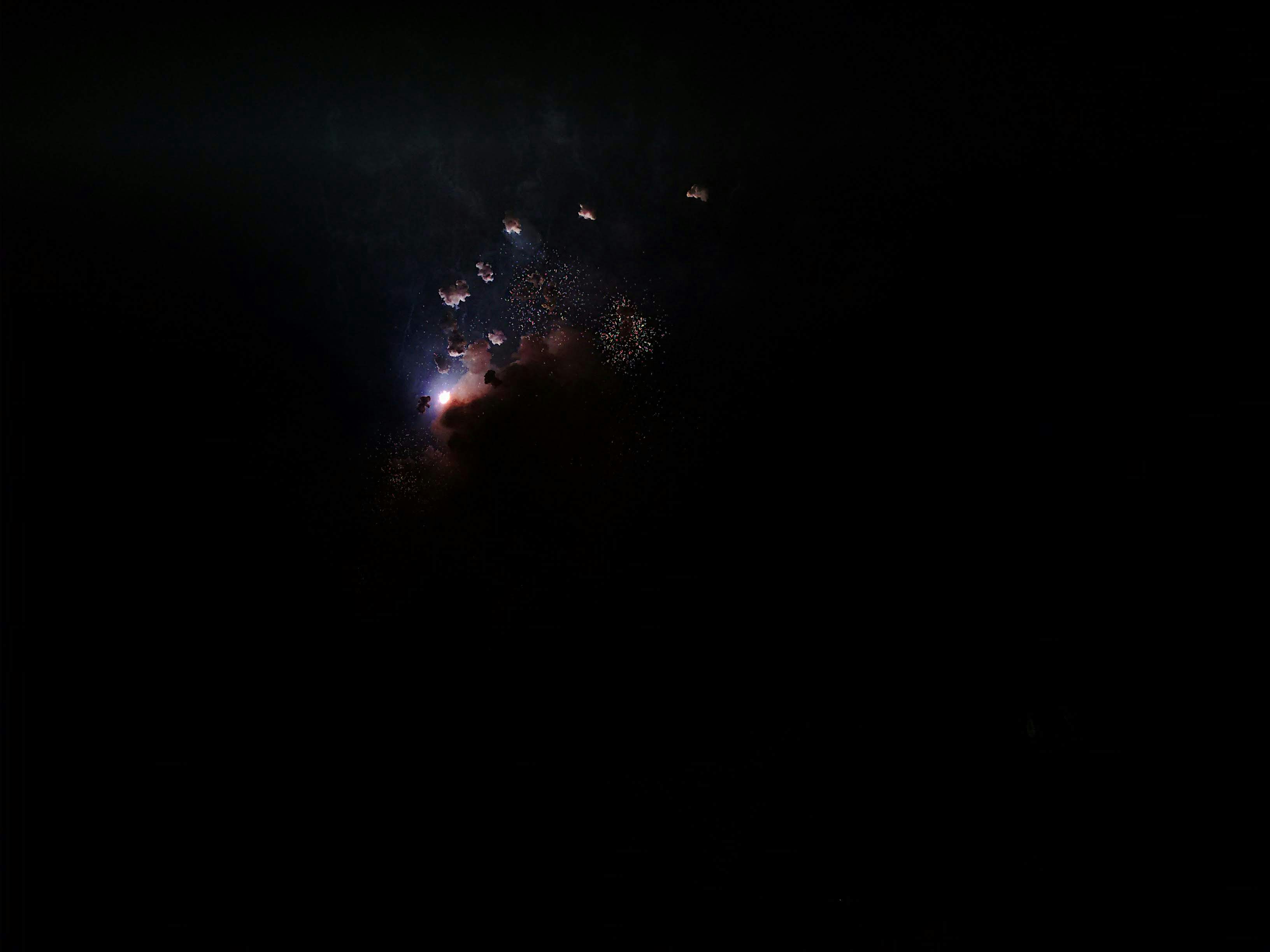 Looking at some fireworks, just took a photo at the exact moment of explotion. It lights up a bit of the smoke in the air, and the sparkles left of past explotions in a completely dark night. Valencia, Spain (2017)