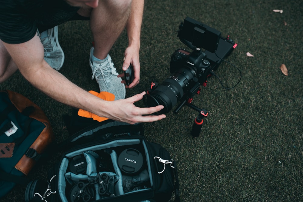 man setting up camera zoom lens