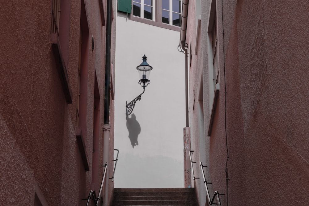 a narrow alleyway with a lamp post and stairs