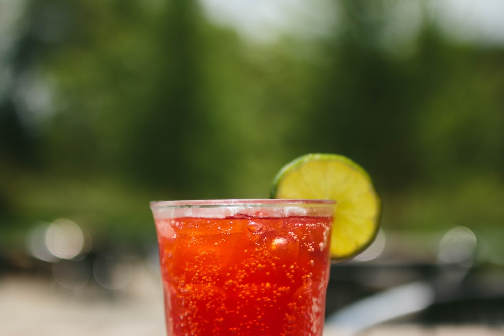 red juice with slice lime on clear glass
