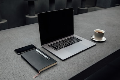 MacBook Pro near cup on desk