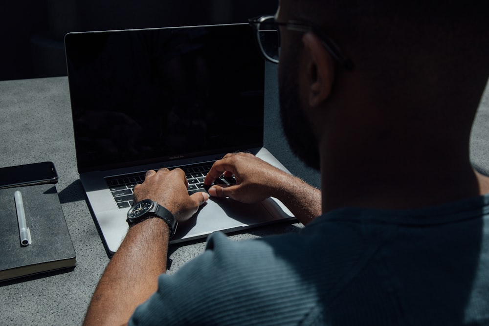 机の上でノートパソコンを使う男