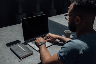 A candid photo of a young entrepreneur working late at a laptop, surrounded by notes and coffee.