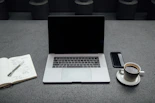 A thoughtful workspace with a laptop, notebook, and a cup of coffee, symbolizing collaboration and innovation.